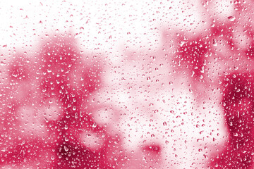 Water drops on glass on abstract red background. Red background