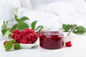 Jar of raspberry jam and fresh berries.