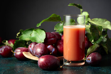 Plum juice and fresh purple plums.