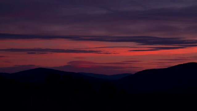 Pink and purple sky sunset timelapse over the mountains.