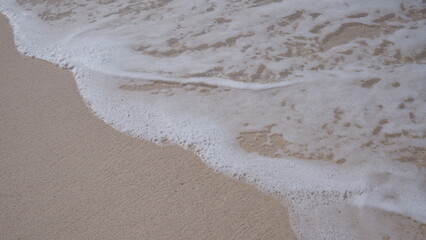View of seashore with foaming waves and clear sand