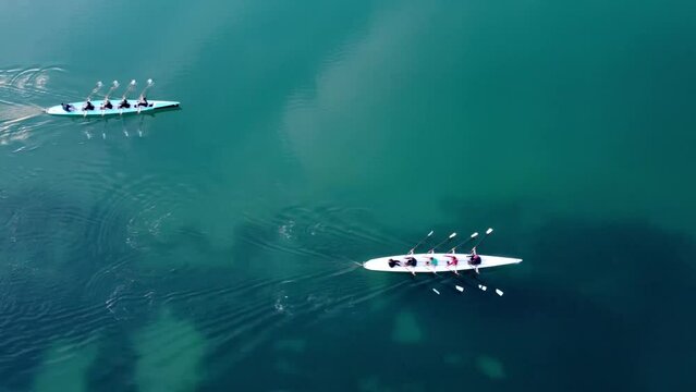 Aerial drone bird's eye view video of two sport canoe operated by team of young men and women . High quality 4k footage