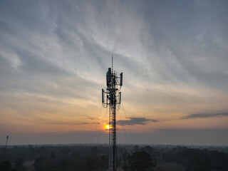 Telecommunication tower of 4G and 5G cellular. Macro Base Station. 5G radio network telecommunication equipment with radio modules and smart antennas mounted on a metal on cloulds sky background. - obrazy, fototapety, plakaty