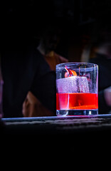 Cocktail Negroni with gin, campari martini rosso and orange in glass on bar counter