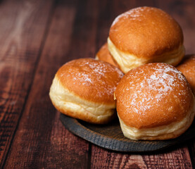 Sweetened Journeys: Austrian Krapfen and German Berliner, Creamy Donut Adventures Await on wooden background. Selective focus
