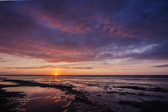 coucher de soleil sur la baie du mont saint michel en bretagne l'&eacute;t&eacute; avec eau au premier plan