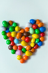 small multi-colored sweets in the form of a heart on a white background