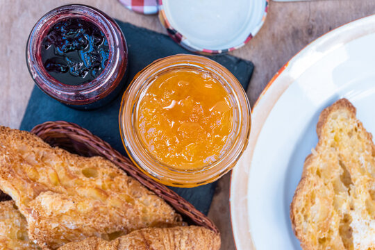 Top view of some open jars with peach and raspberry jam.