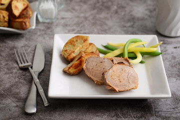 roast pork dinner with knife and fork - 483769391