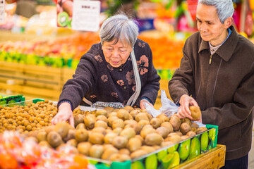 Senior Man and Woman Shopping Fruit. A  senior couple, 80 years old, is selecting fruits in a supermarket..