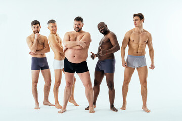 Group of multiethnic men posing for a male edition body positive beauty set. Shirtless guys with...