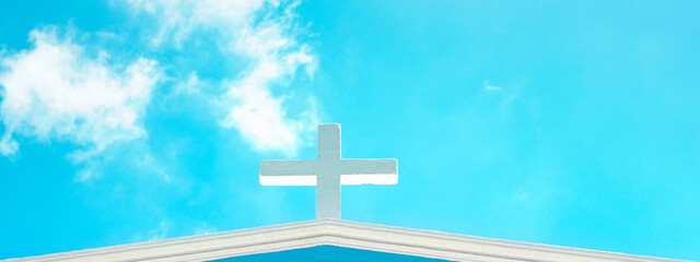 Church cross on top of roof on blue sky background