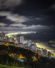 Fototapeta premium Vista do alto de noite com uma cidade a beira mar