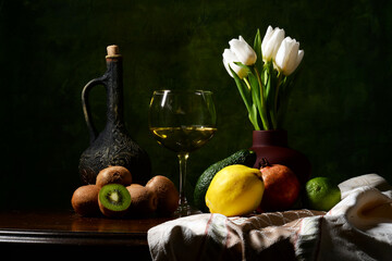 martwa natura z owocami na zielonym tle. winogron, granat, pomarańcz, jabłka, białe tulipany w kompozycji. butelka wino, kieliszek z winem, kompozycja na tekstura lub tapeta na pulpit. 