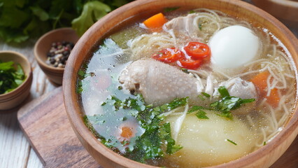 South American Caldo de Gallina chicken noodle soup with boiled egg and herbs. The classic Peruvian chicken noodle soup.