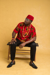 Igbo Traditionally Dressed Business Man Sitting Down and Posturing