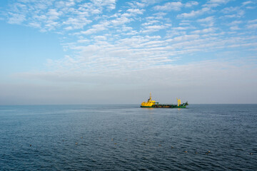 Hopper dredger ship is working to deepen the fairway on the sea. Baltic Sea, Poland - obrazy, fototapety, plakaty