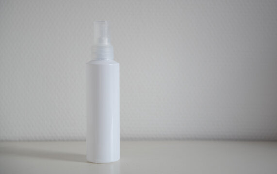 Flacon blanc devant un mur blanc - mock up pour pouvoir y insérer texte et design - produit cosmétique
