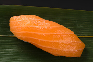sushi with red salmon fillet on bamboo leaf, close-up