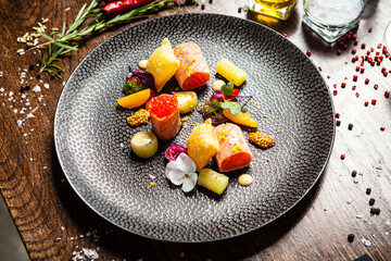 Salted Scottish salmon with trout roe. Marinated cucumber and onion, wonton chips. Delicious healthy Italian traditional food closeup served for lunch in modern gourmet cuisine restaurant