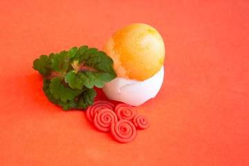 Sprout, spirals and egg on orange background