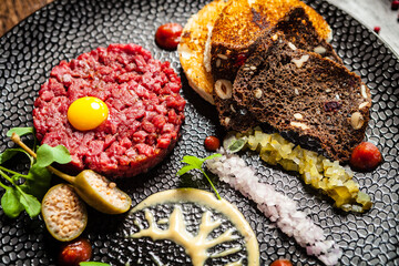 Beef tartare from Black Angus. Onion, quail egg, tomato sauce, mustard mayonnaise. Delicious healthy Italian traditional food closeup served for lunch in modern gourmet cuisine restaurant
