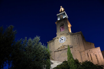 Fototapeta na wymiar Clocher et façade de l'église Saint-Louis de Sète éclairés la nuit (Occitanie, France)