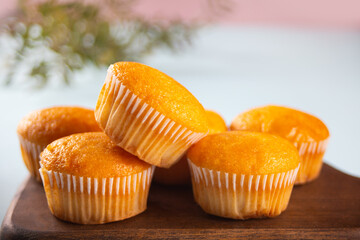 Fresh homemade vanilla cupcakes on wooden board.