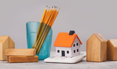 mortgage calculator or real estate business concept. Office desk with a white and wooden houses....