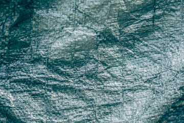 Abstract real fabric surface background. Aluminum Platinum Silver foil Tarpaulin effect with rough texture burlap edge. Futurism 80s retro style new year. Dark Grey Turquoise tone design. More stock