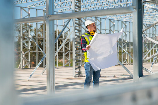 Handsome young man Architect  reviewing blueprint in construction site