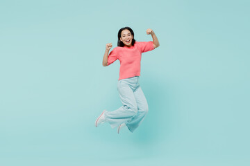 Full body young excited happy woman of Asian ethnicity 20s wearing pink sweater jump high do winner...