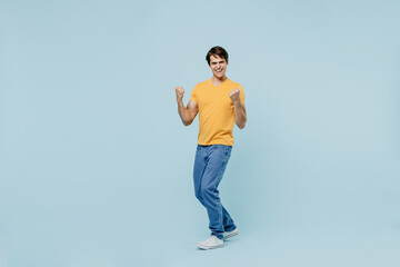 Full body overjoyed excited satisfied happy cool young man 20s in yellow t-shirt do winner gesture...