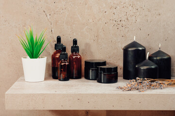 SPA treatments and scented candles standing on a shelf in dark brown flowers with a small potted plant. Aromatherapy body care products from environmentally friendly products.