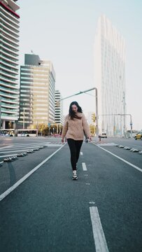 Carefree woman walking along street in downtown