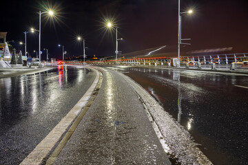 The empty wet road at rainy night in the center of Istanbul city.