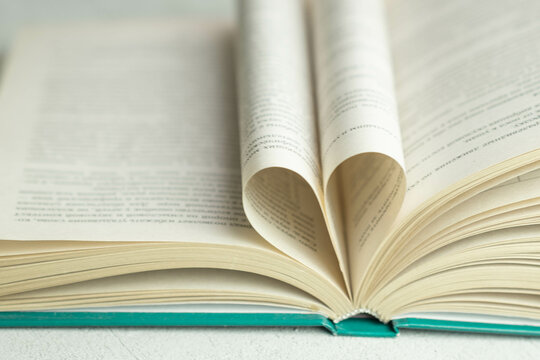 an open book with folded pages in the shape of a heart , the concept of Valentine's day, blurred background