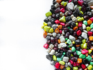 Candy multi-colored sea stones on a white background. Place for text