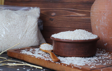 Close up the rice on wood spoon put on the rice sack with blurry of pile rice