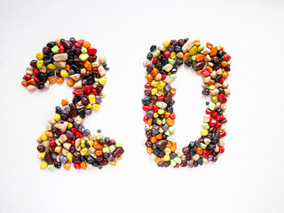 Number twenty from multi-colored candy stones on a white background