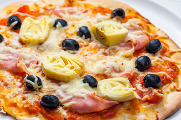 pizza with ham, black olives and artichokes