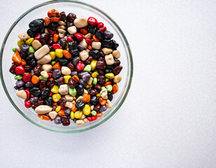 Sweets in a glass plate on a white background. Multicolored sea stones