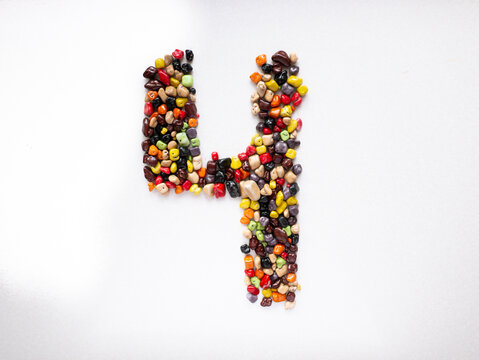 Number four from multi-colored candy stones on a white background