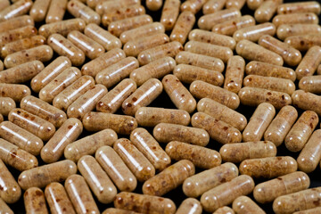 brown capsules (lecithin) on a dark background
