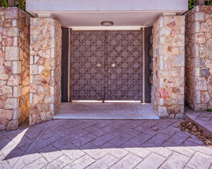 classic design house entrance darks iron double doors and stone wall fence