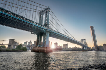 View of Manhattan Bridge and east river at Suntet with Mahattan skyline in the background - NYC, Brooklyn, USA