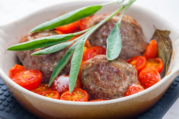 meat balls with tomatoes baked with sage