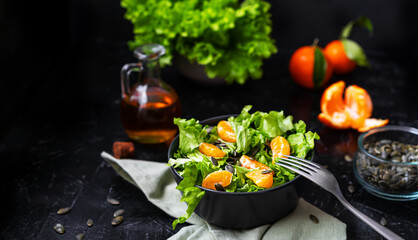 Lettuce salad with tangerines, olive oil, pumpkin seeds