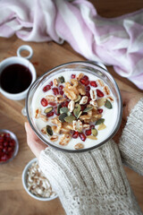 Healthy breakfast with yogurt, nuts, cereals and pomegranate seeds. Healthy snack packed with vitamins and antioxidants