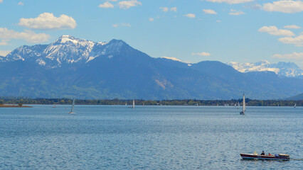 Boat sailing in the lake, mountains with peaks covered in  snow
